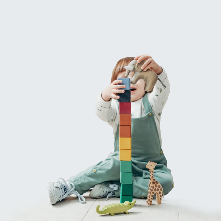 Enfant qui fait une pile de jouets en bois - micro crèche Baby chou à Meulay